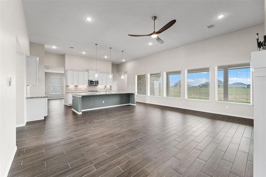 The kitchen is open to the living space with wood look tile flooring and high ceilings. You will love the expanse of windows and the amount of natural light controlled by 2" blinds, but mostly that the large lot still allows you plenty of privacy.