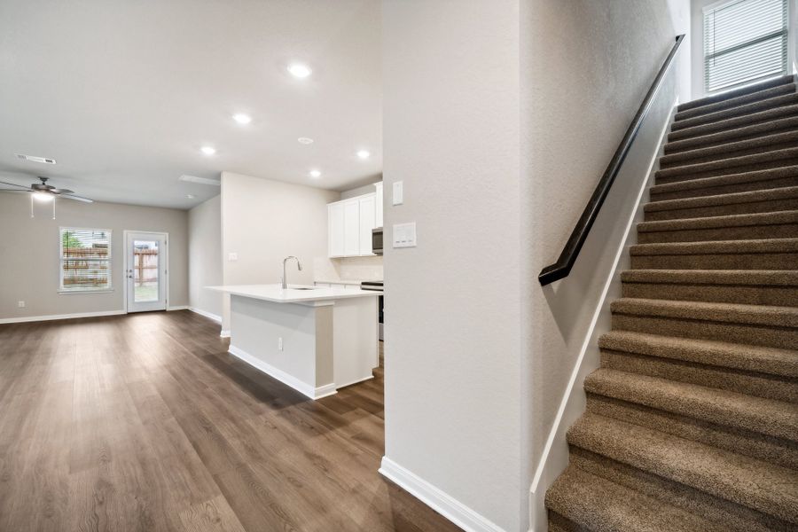 Kitchen and staircase in the Reynolds floorplan at a Meritage Homes community.