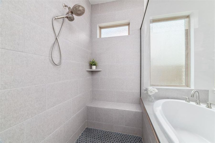 Separate Modern glass-enclosed walk-in-shower with a textured tile floor finish.