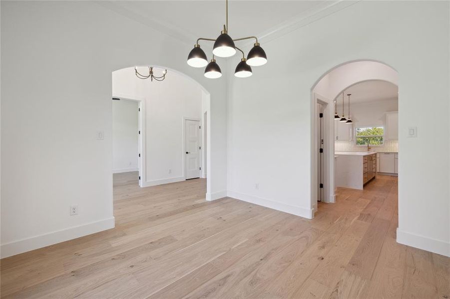 Unfurnished dining area with an inviting chandelier and light hardwood / wood-style flooring