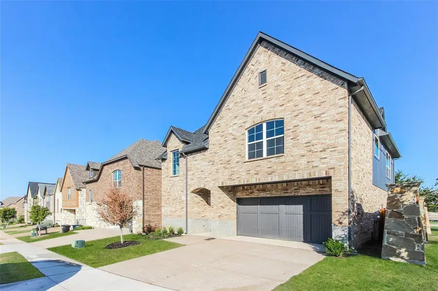 View of front of house featuring a garage and a front lawn