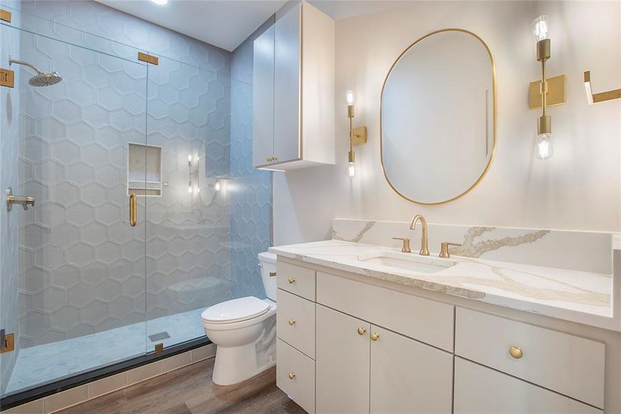 Bathroom featuring hardwood / wood-style floors, vanity, a shower with door, and toilet