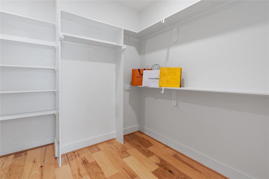 This walk-in closet, designed for the neat freak, boasts ample storage space, well-organized shelving, and a meticulously planned layout, ensuring every item has its own designated place.