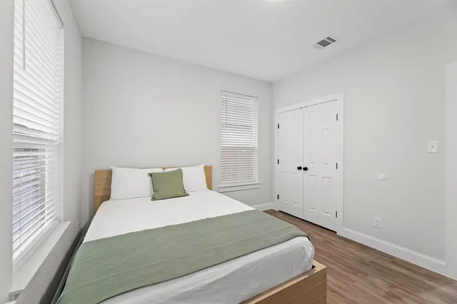 Bedroom featuring a closet, multiple windows, and hardwood / wood-style flooring