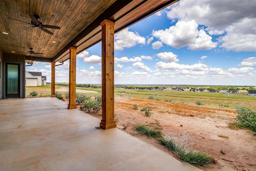 View of patio with ceiling fan and a rural view