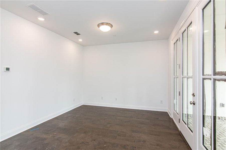 Media / Office room featuring dark hardwood / wood-style floors and french doors, not the actual unit