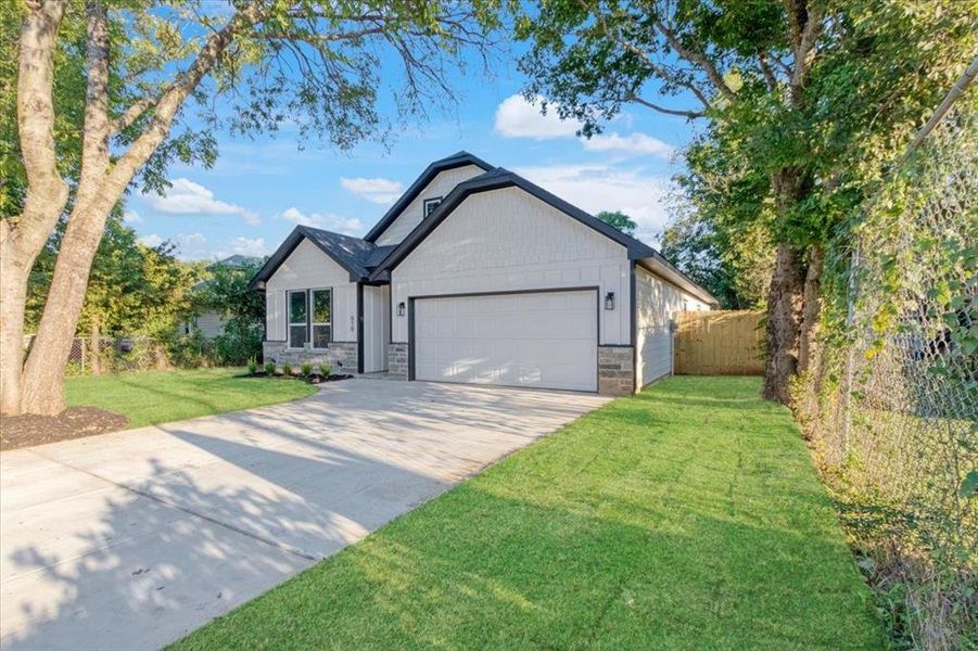 View of front of home featuring a garage and a front lawn