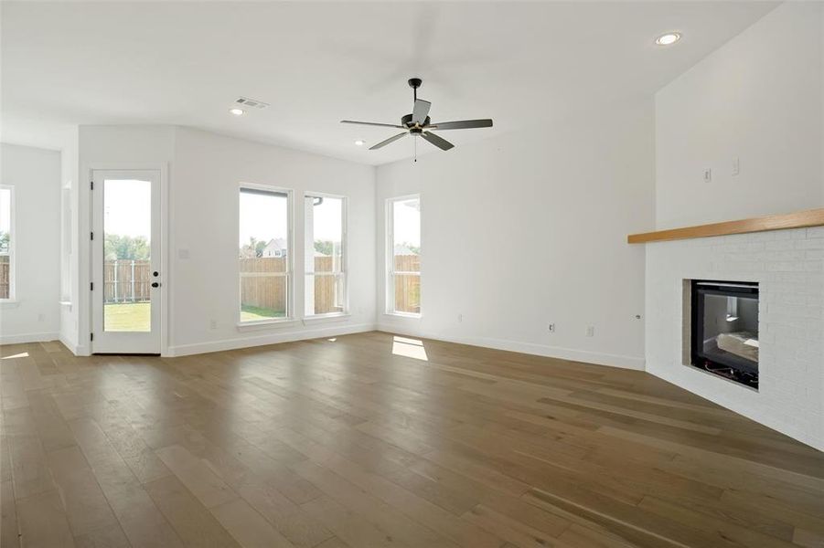 Unfurnished living room with dark hardwood / wood-style floors, a fireplace, and ceiling fan