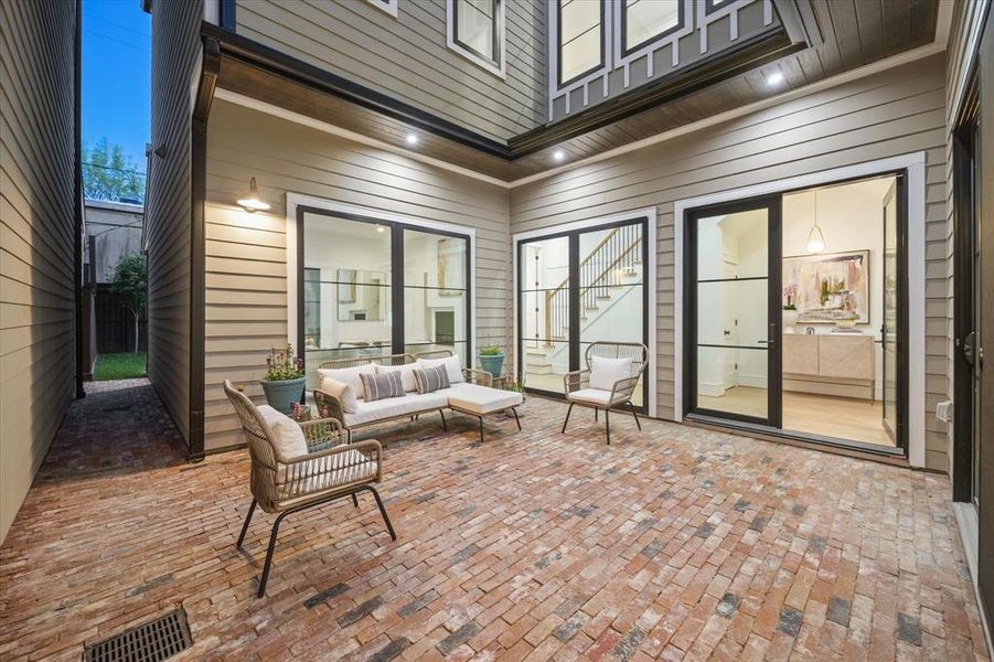There is a lovely courtyard entrance with brick pavers, lighting, and a sitting area. There is also a gas and water connection is this area. The Patio is Approx. 17 x 16 per builders plans.