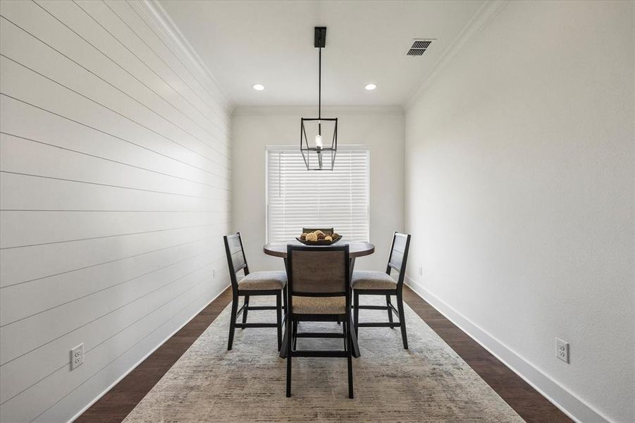 Dining room featuring dark wood-type flooring, a chandelier, and crown molding