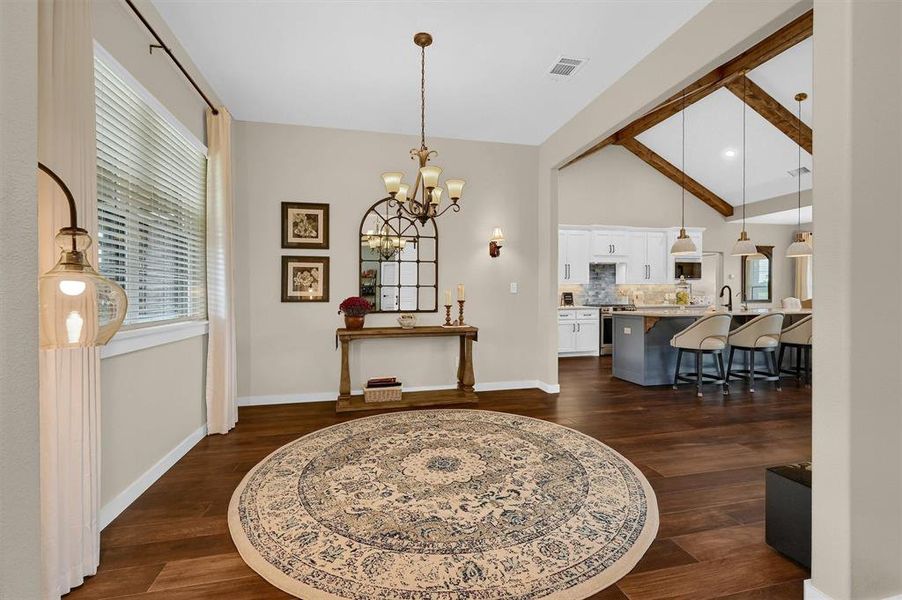 Dining room featuring vaulted ceiling, a notable chandelier, and dark hardwood / wood-style floors