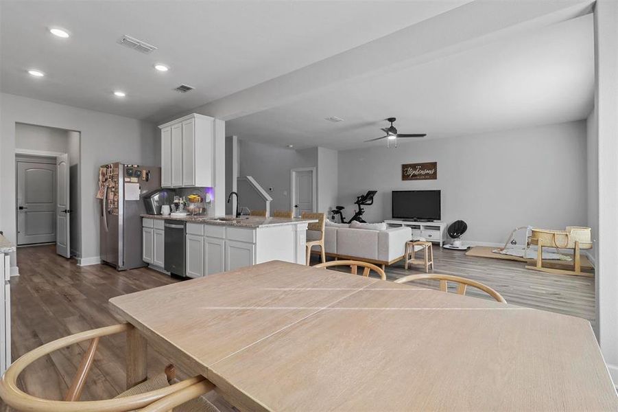 Dining area with sink, dark wood-type flooring, and ceiling fan