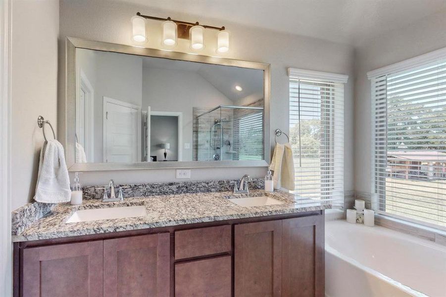 Bathroom featuring separate shower and tub and double sink vanity