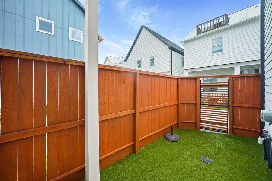 The backyard features turf and solid board fencing for more privacy.