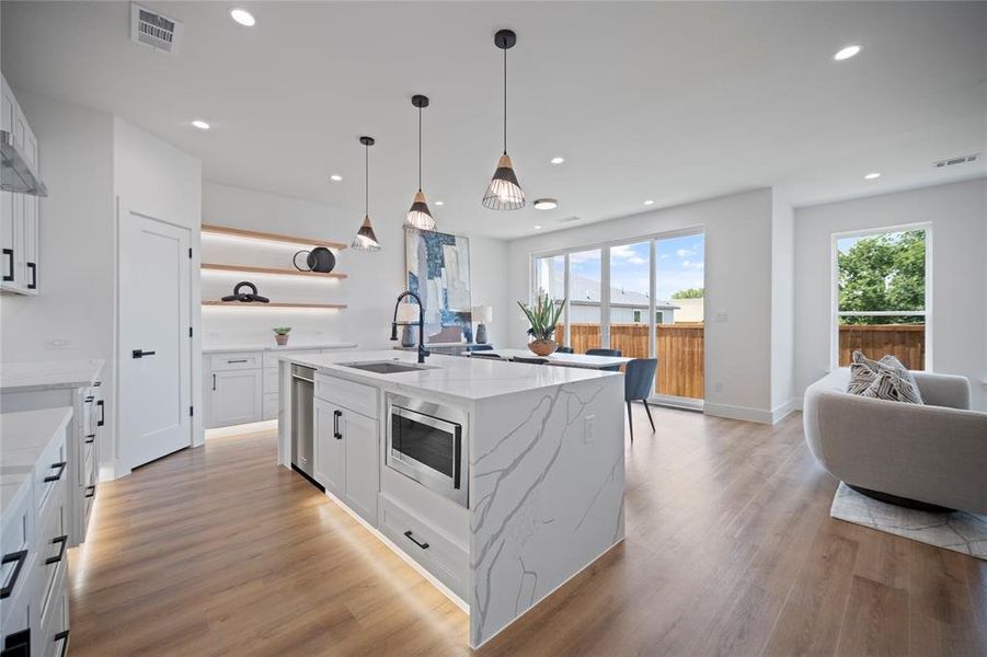 Kitchen featuring white cabinets, a kitchen island with sink, stainless steel appliances, hardwood / wood-style floors, and sink
