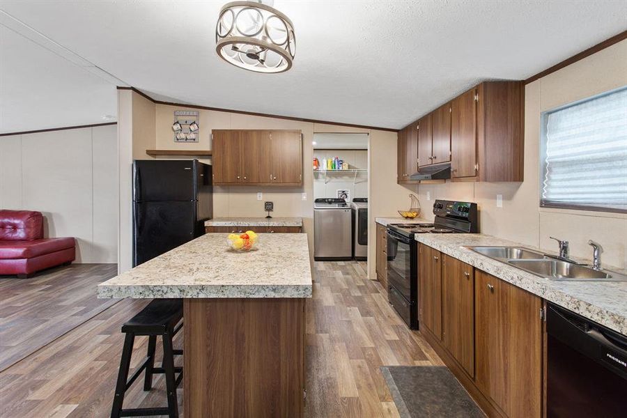 Rich wood-colored cabinetry offers ample storage, complementing the laminated countertops that provide plenty of prep space.