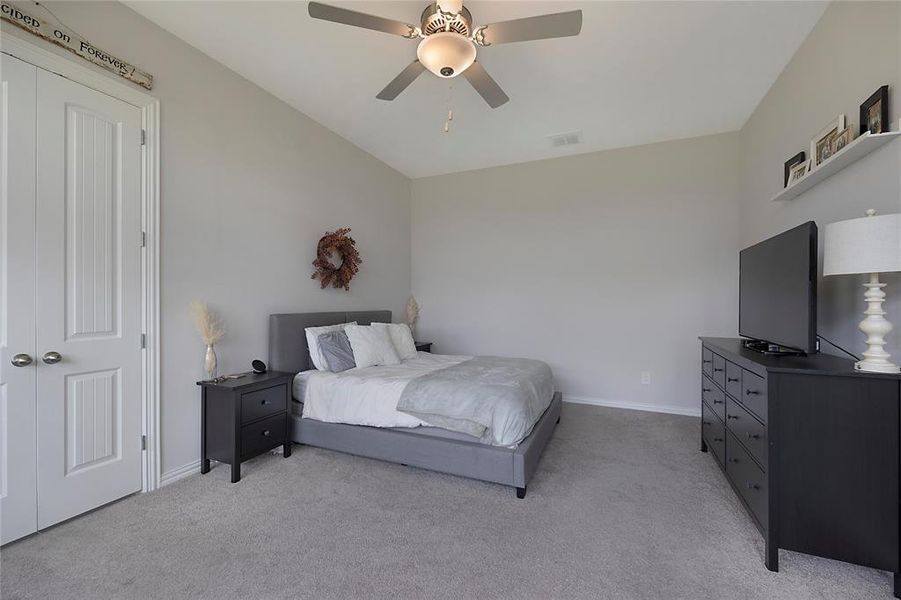 Bedroom with light carpet, a closet, and ceiling fan