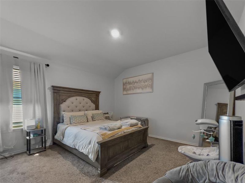 Bedroom with carpet floors and vaulted ceiling