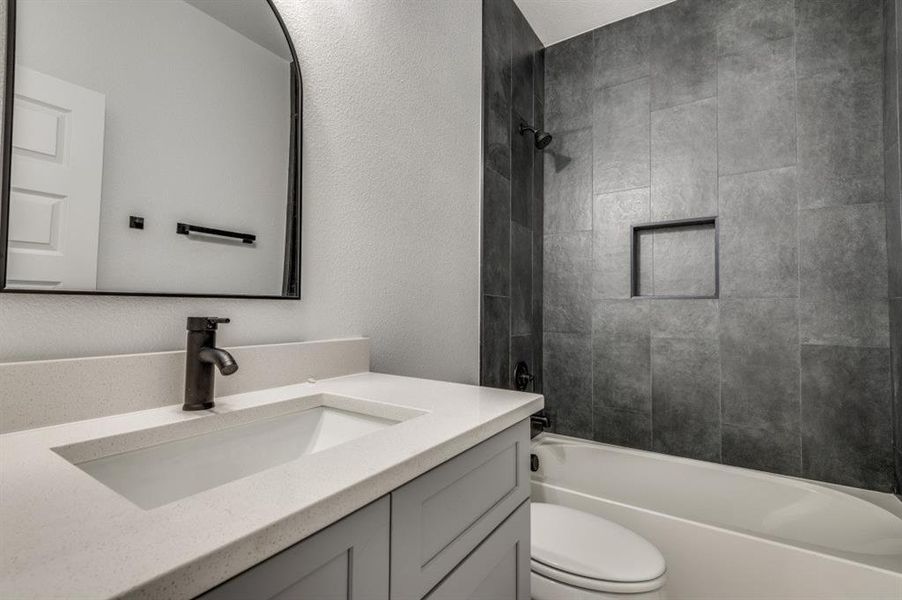 Full bathroom with tiled shower / bath, toilet, and vanity