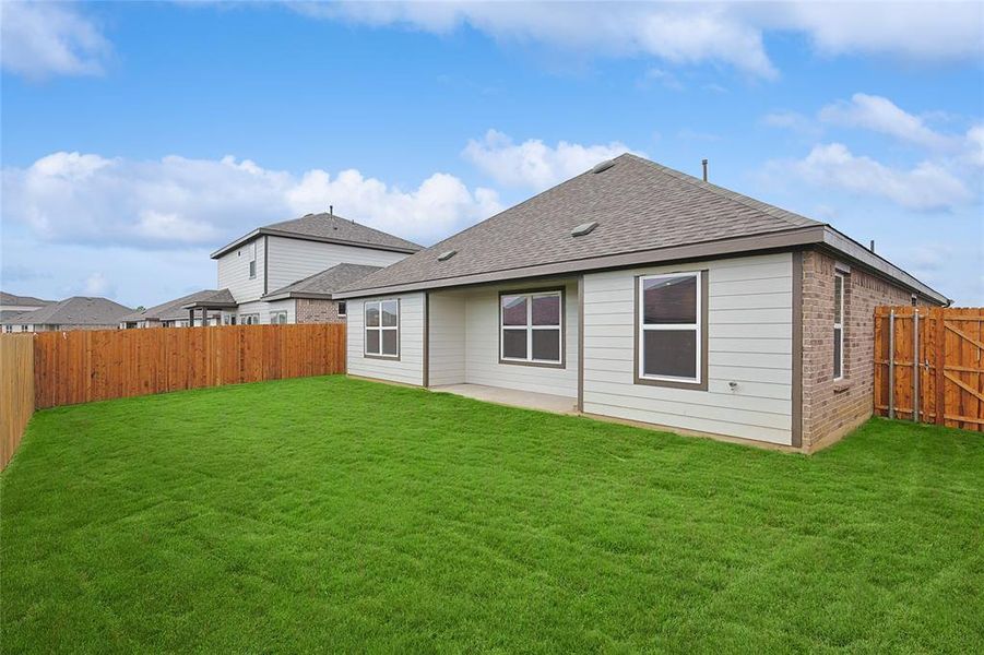 Rear view of property with a yard