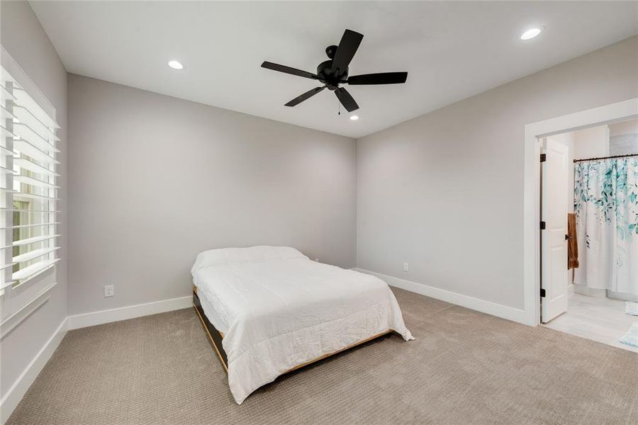 Carpeted bedroom featuring ceiling fan