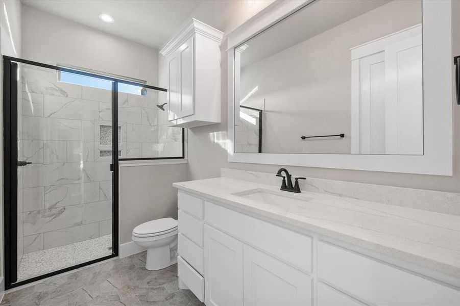 Bathroom with toilet, walk in shower, and vanity