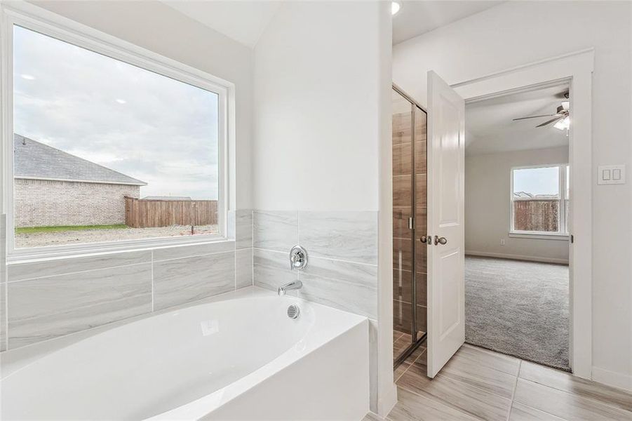 Bathroom with independent shower and bath, ceiling fan, and tile patterned floors