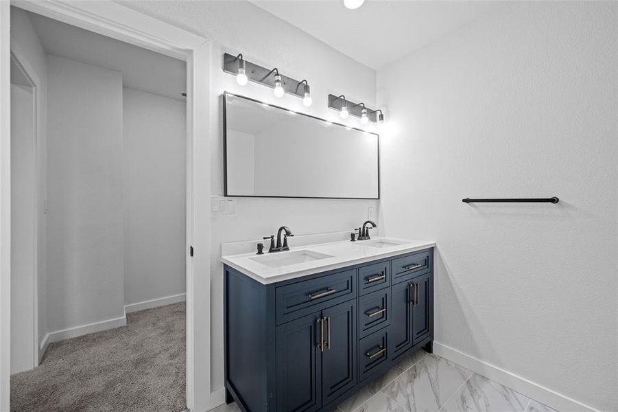 Bathroom featuring tile patterned floors and dual bowl vanity