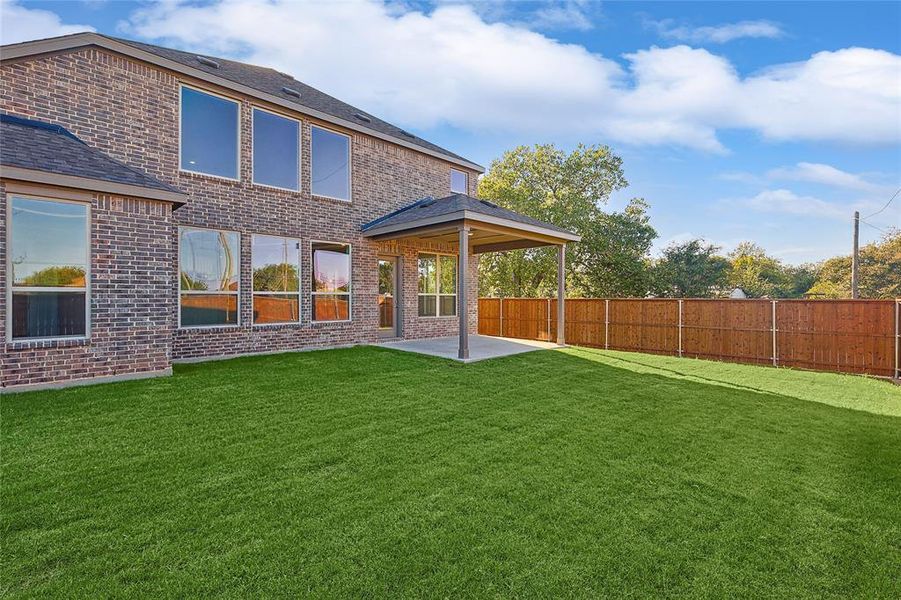 Back of property with a yard and a patio