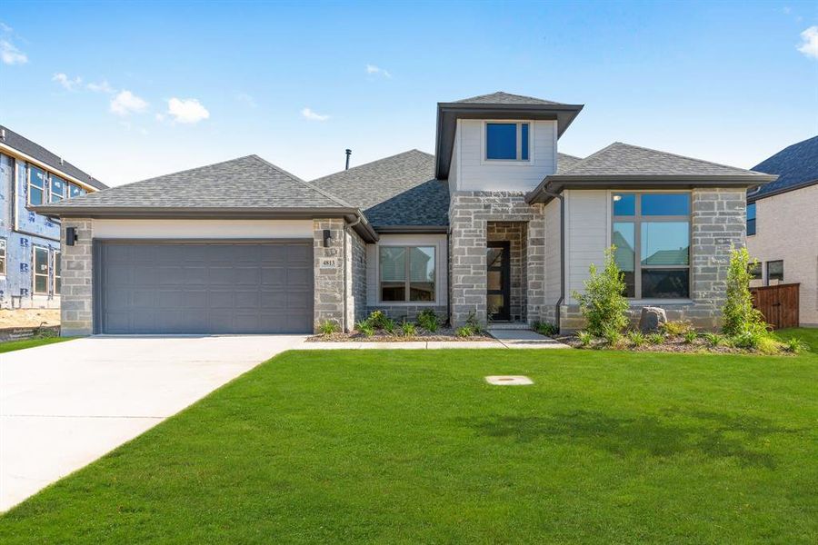 View of front of house with a front lawn and a garage