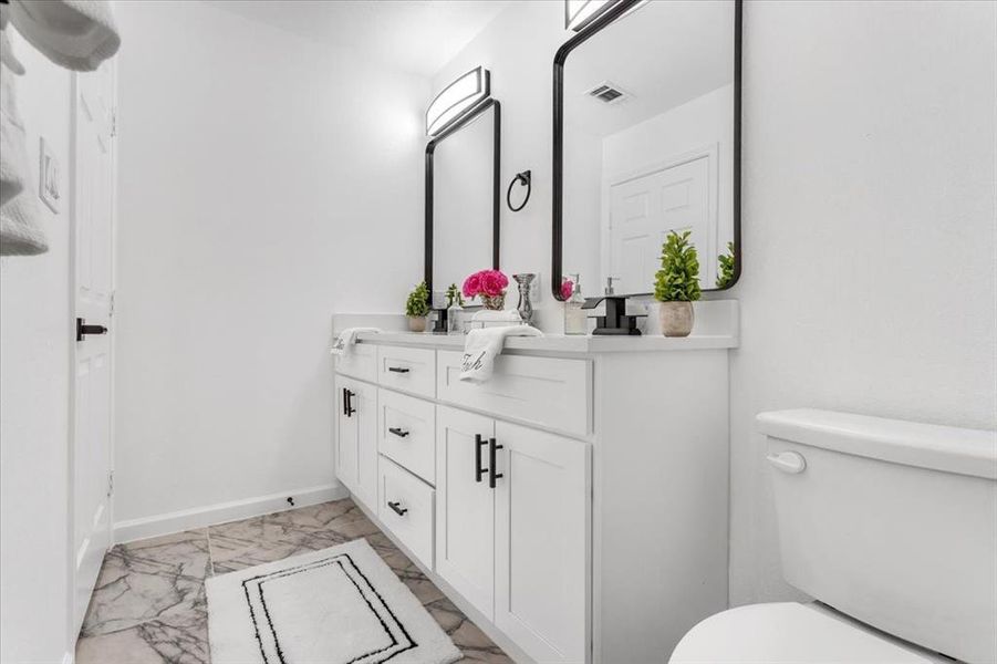 Bathroom with tile floors, vanity, and toilet