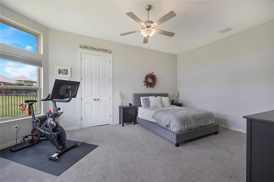 Bedroom with ceiling fan, carpet flooring, and a closet