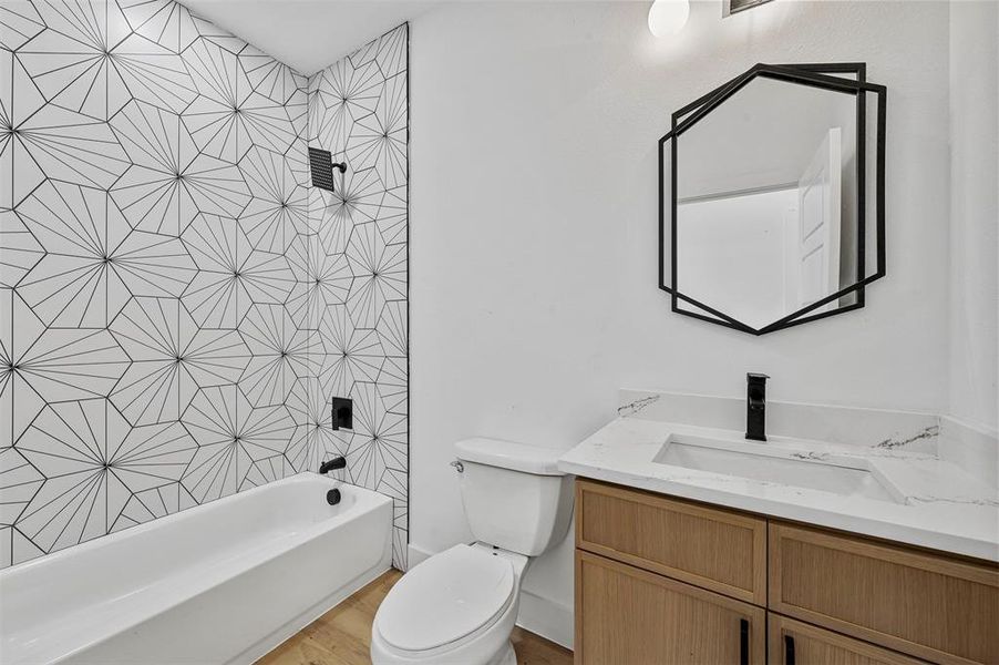 Full bathroom with shower / washtub combination, vanity, toilet, and hardwood / wood-style floors
