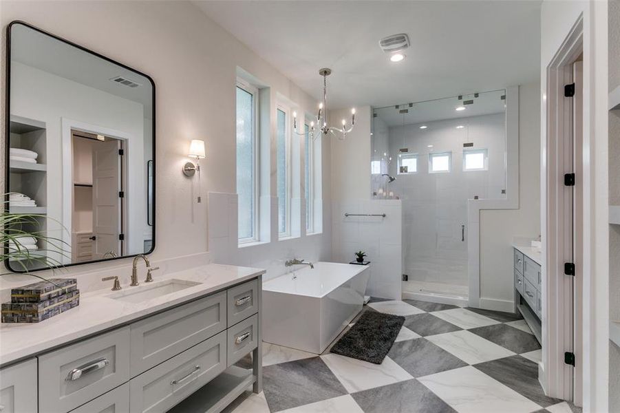 Bathroom with a notable chandelier, tile flooring, independent shower and bath, and vanity