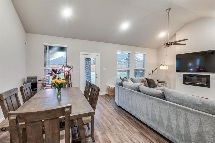 Dining space featuring wood-type flooring, ceiling fan, and vaulted ceiling