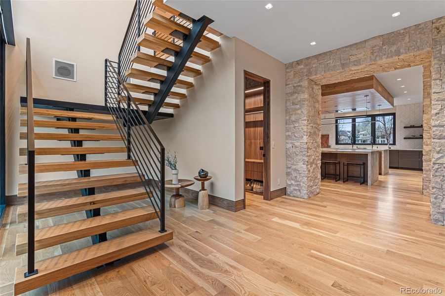 A grand 26-foot high foyer features a majestic white oak ceiling and mono-stair floating staircase with solid white oak treads and artisan crafted ironwork railings. The second level can also be accessed by the elevator.