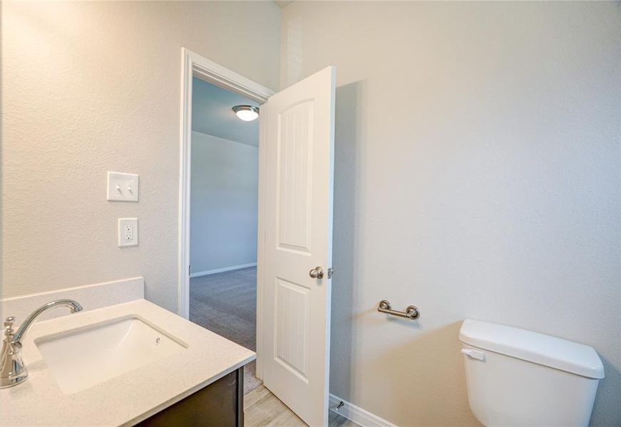 This secondary bath features modern fixtures and a functional layout. It includes a sleek vanity with ample storage, a spacious mirror, and a well-designed shower or tub area. The room is complemented by neutral colors and efficient lighting, offering both style and convenience.