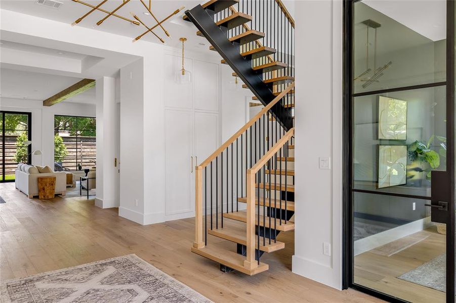 Stairway featuring a notable chandelier, beam ceiling, and hardwood / wood-style floors