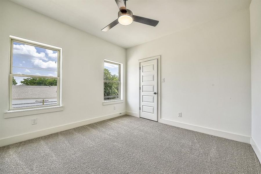 Unfurnished bedroom with ceiling fan and carpet floors