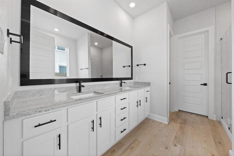 Master bathroom includes granite countertop, elongated mirror, and dual-vanity sinks. Relax in the large soaking tub or enjoy the spacious, standing shower.