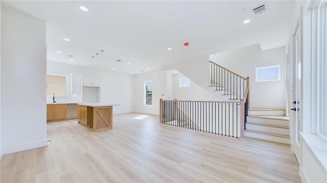 Alternate view of the open-concept living areas, featuring wood-like LVP flooring throughout, offering a sleek, carpet-free design.