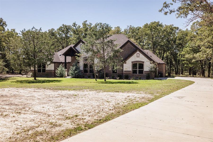 French provincial home featuring a front yard