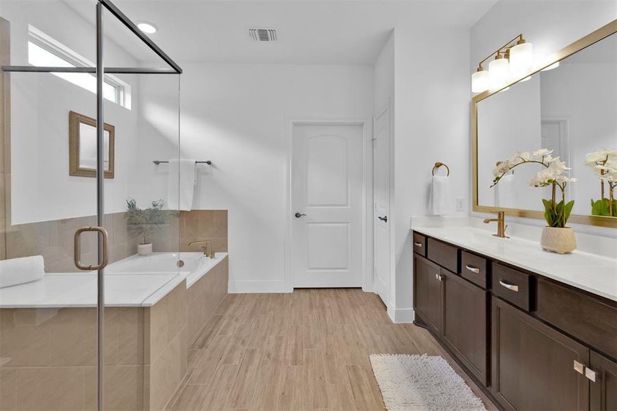 Ensuite master bathroom features double sinks, upgraded layout, wall tile shower surround, and upgraded gold plumbing fixtures.