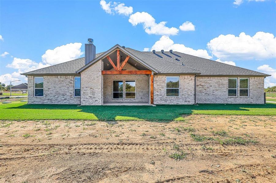 Back of property featuring a patio area and a yard