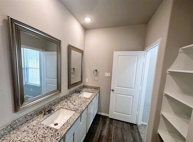 Double sinks, granite counters, framed mirrors, shelving- this master bath has everything!