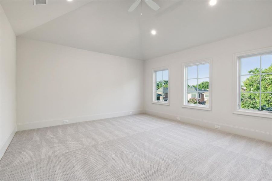 Carpeted spare room with lofted ceiling and ceiling fan