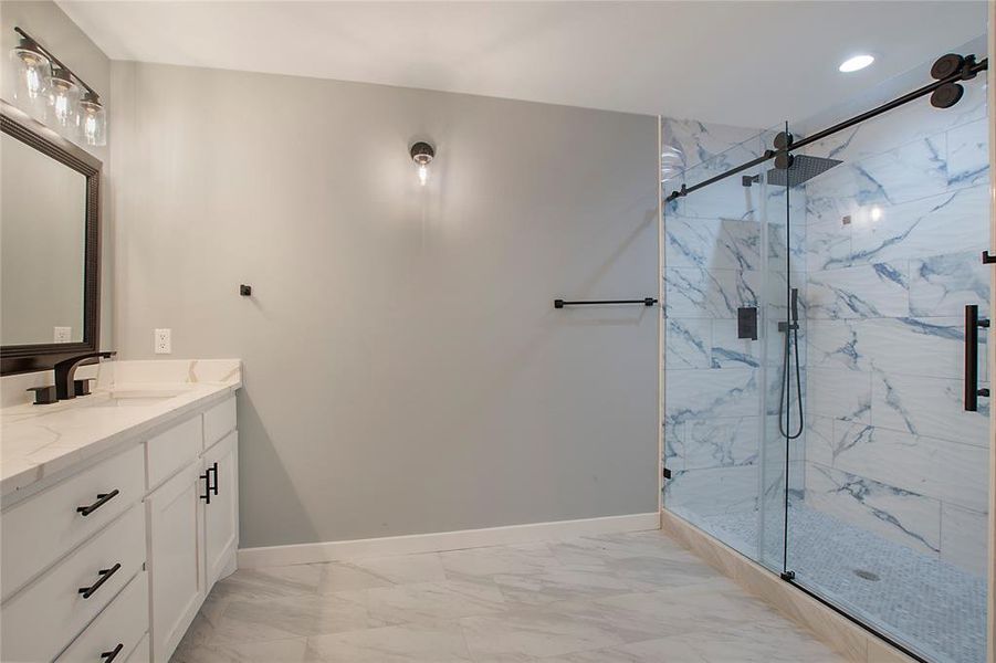 Bathroom featuring a shower with door and vanity