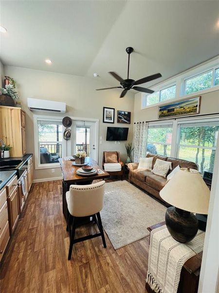 Living room featuring wood-type flooring, a wealth of natural light, and ceiling fan