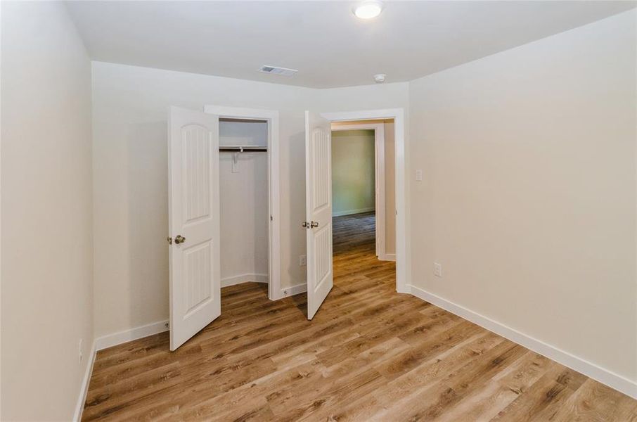 Unfurnished bedroom with light wood-type flooring and a closet