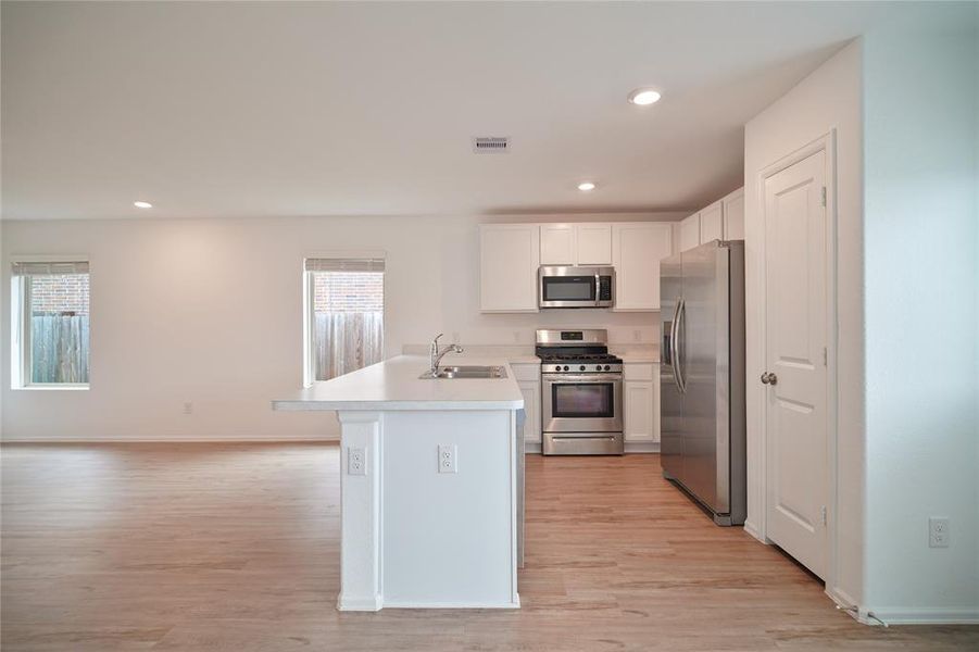 A functional and visually appealing kitchen that features a complete set of appliances, including a range, oven, microwave, dishwasher, and refrigerator.